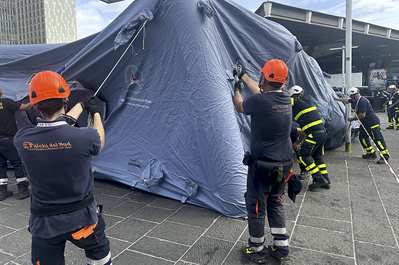Volontari di protezione civile montano una tenda