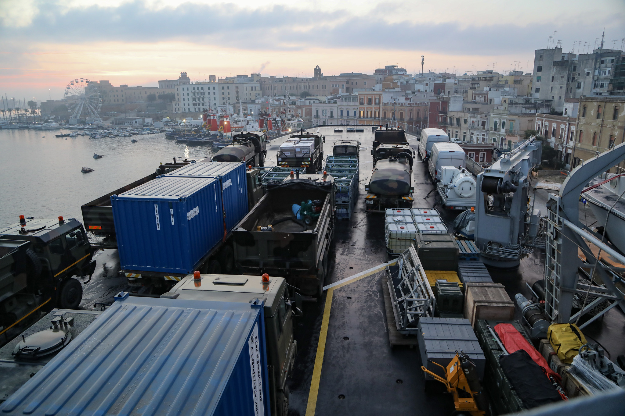 Mezzi al porto di Brindisi all'alba, durante le operazioni di carico di Nave San Marco